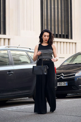 a lady in a black striped tank top and a pair of black wide leg pants